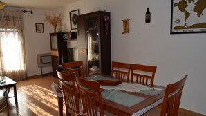 Ein Essbereich mit Holztisch und Stühlen, einem Schrank mit Glastüren sowie einer Karte an der Wand.