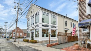 Un edificio a due piani con una vetrina che recita “RIEHLE OPTICIANS” e una bandiera americana.
