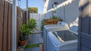 A small, enclosed outdoor area with a wooden fence, a hot tub, and potted plants. - 5 mins to Coral Gables/ Parking/ Fast Wi-Fi/ Laundry (Miami)