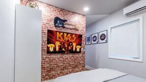 A bedroom with a brick wall, a guitar, and framed pictures. - 5 mins to Coral Gables/ Parking/ Fast Wi-Fi/ Laundry (Miami)