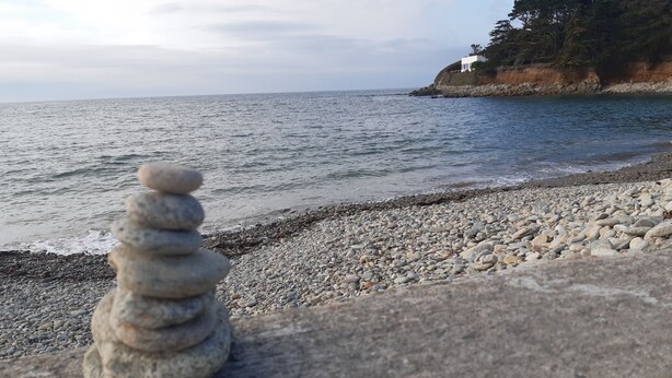 A pebble beach with a stack of stones and a view of the ocean. - Charming little house 5 minutes' walk from the beach (Locquirec)