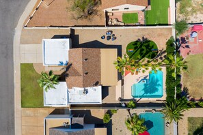 Vista aérea de una zona residencial con piscina, mobiliario de patio y una pequeña terraza.