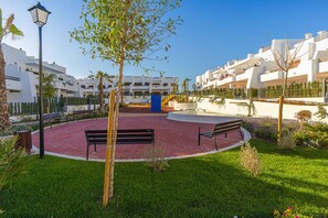 A courtyard with benches, a lamp post, and a blue structure.