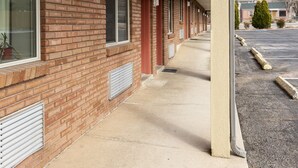 A motel with a brick facade, large windows, and a covered walkway.