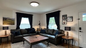 Een woonkamer met een zithoek, een salontafel en twee lampen.