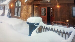 Una cabaña de madera con un porche cubierto de nieve y un letrero que dice "Macdonald 0873 4EHRON".