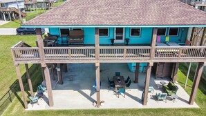 Une maison à deux étages dotée d’un balcon, d’un espace extérieur aménagé pour s’asseoir et d’un garage.