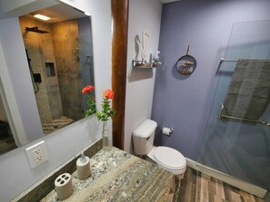 A bathroom with a glass shower enclosure, a toilet, and a sink with a marble countertop. - Sunset and Ocean views at Sandy Feet Retreat with private infinity pool. (Sandy Bay)