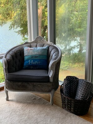 Relax in a cozy corner with a view of the water and trees.