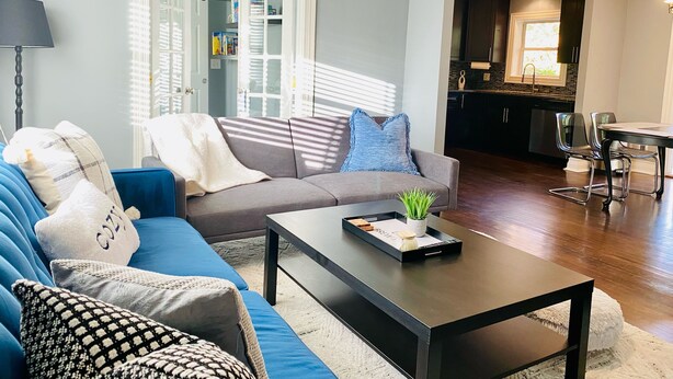 Un salon comprenant un canapé, une table basse et un coin repas avec des chaises.