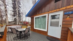 A wooden deck with a table and chairs, a covered outdoor seating area, and a house number 1710. - Cozy centrally located two-bedroom home. Pet friendly!  (Fairbanks)