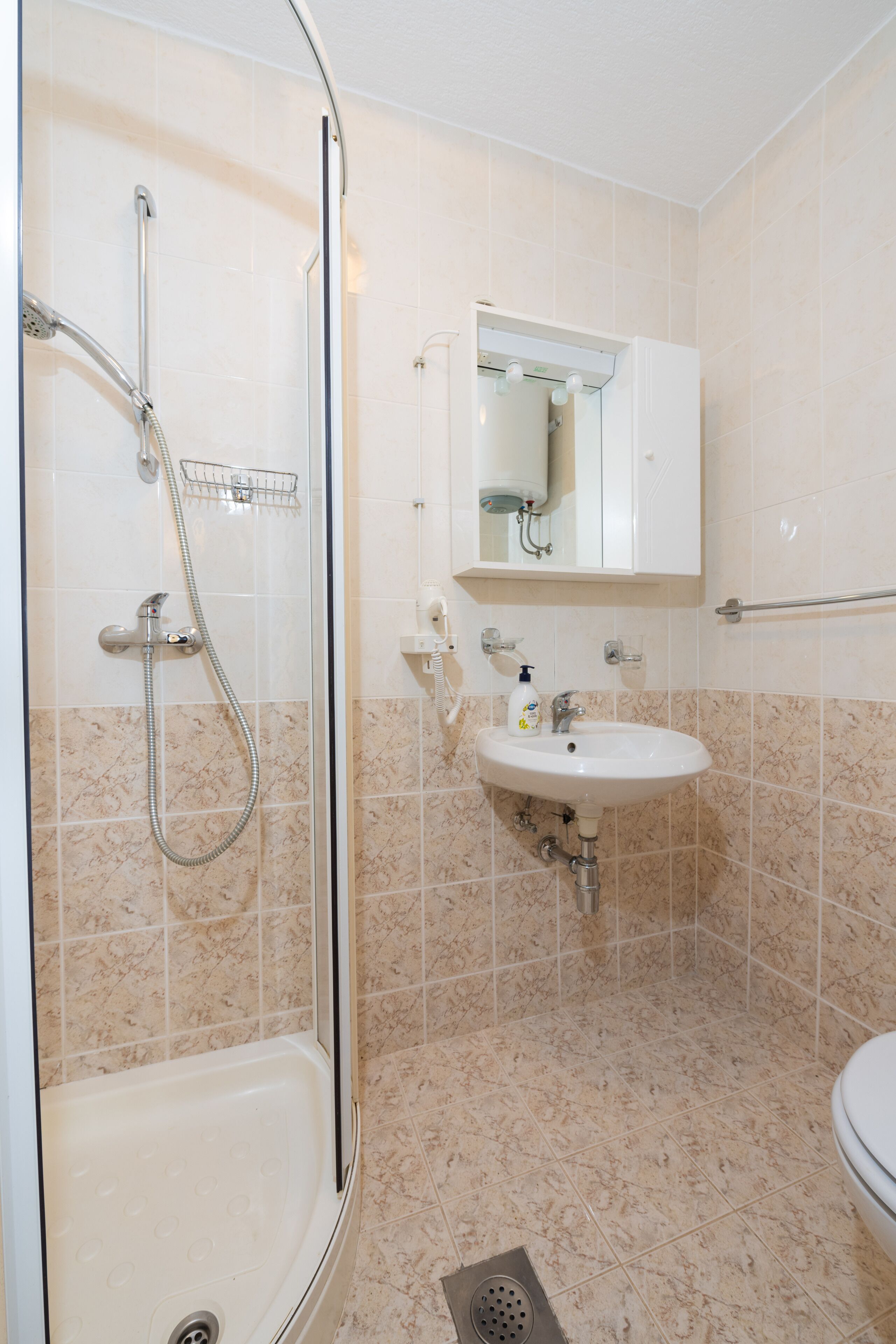 Ein Badezimmer mit Duschkabine, Waschbecken und Toilette.