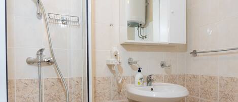 Ein Badezimmer mit Duschkabine, Waschbecken und Toilette.
