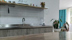 Eine Küche mit einer Holzarbeitsplatte, einem Spülbecken und einer Spritzschutzwand.