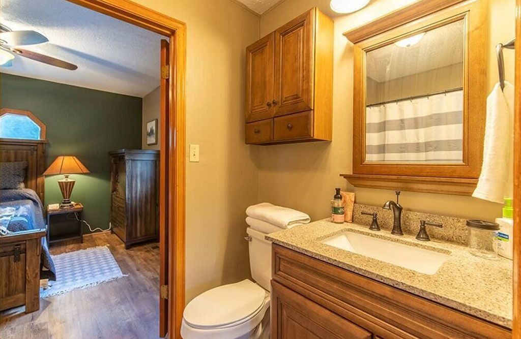 Un baño con armarios de madera, un lavabo y un inodoro.