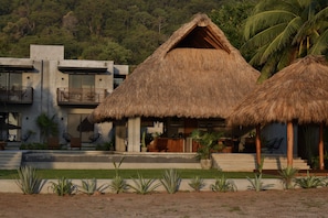 A modern building with a thatched roof, a pool, and a landscaped garden. - Casa Costamor - Beach front villa w/ 4 suites (Municipio de la Union, Montes de Oca)
