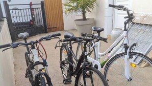 En cykel parkeret i en gårdsplads med en hvid bygning i baggrunden.