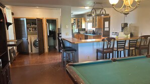 A compact living space with a pool table, a kitchen area, and a dining area with chairs. - Spacious House North of Gunnison (Gunnison)