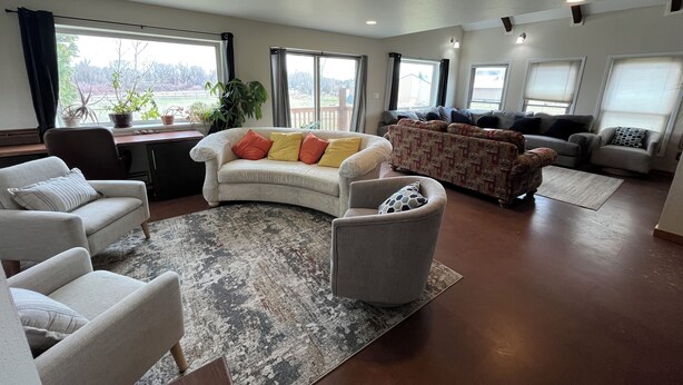 A spacious living room with a curved sofa, armchairs, and a coffee table. - Spacious House North of Gunnison (Gunnison)