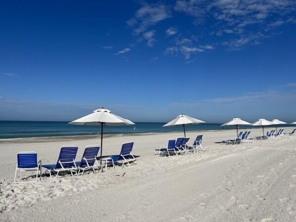 Lounge chairs with umbrella set on the private sandy beach