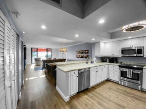 Open-plan great room showing kitchen, dining, and living areas in a single flowing space