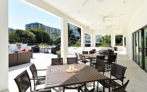 Outdoor terrace seating area at the clubhouse with resort grounds in the background