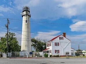 Un faro y una casa blanca con techo rojo.
