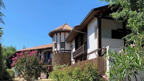 A traditional house with a stone foundation, a wooden balcony, and a tiled roof. - Apartment with terrace in residence with swimming pool (Biscarrosse)