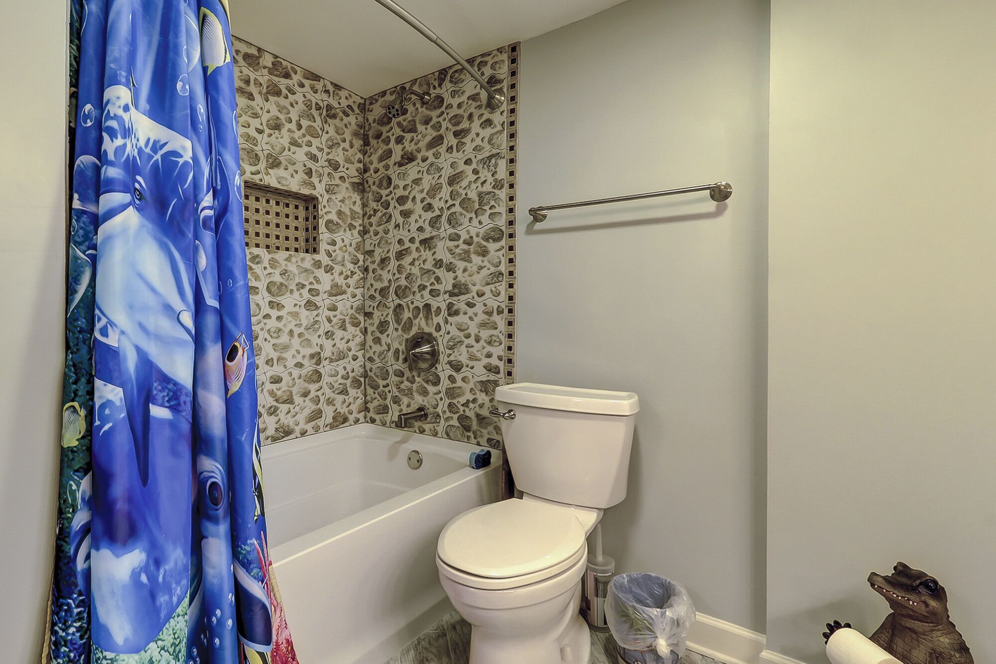 A bathroom with a bathtub, toilet, and shower curtain.