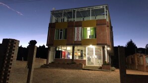 A two-story building with a glass facade and a brick exterior. - Playa Blanca El mana (Boyacá)