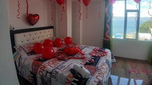 A bedroom with a bed, balloons, and a view of the sea. - Playa Blanca El mana (Boyacá)