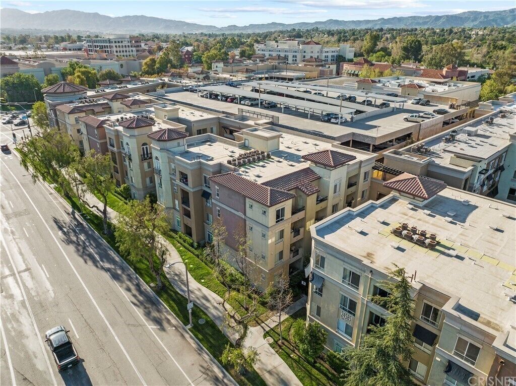 Un edificio residencial de varios pisos con un estacionamiento al frente.