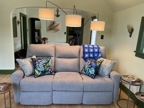 Relax in this stylish living room with a sofa, round table, and abstract art.
