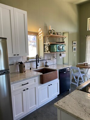 Enjoy cooking in this well-equipped kitchen with a stainless steel refrigerator, dishwasher, and microwave.