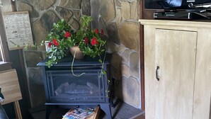 A stone wall, a black wood-burning stove, a television, and a cabinet. - Near SkiSawmill 5 mi ETAR,STAR Archery, PAWA events. On the stream!   (Waterville)