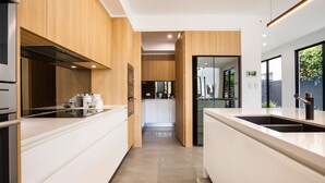 A modern kitchen with white cabinetry, stainless steel appliances, and a central island. - Stunning Waterfront Home in Surfers Paradise.
Heated Pool and Pet Friendly (Surfers Paradise)