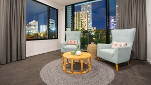 A modern living room with two armchairs, a round wooden coffee table, and a view of a cityscape at night. - Stunning Waterfront Home in Surfers Paradise.
Heated Pool and Pet Friendly (Surfers Paradise)