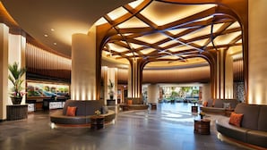 Un'ampia hall con travi in legno curve, zone relax confortevoli e vista sull'esterno.