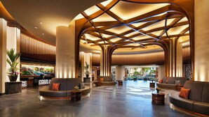 Un'ampia hall con travi in legno curve, zone relax confortevoli e vista sull'esterno.