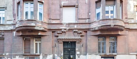 A historic building with a black ornate entrance, multiple windows, and a visible door number.