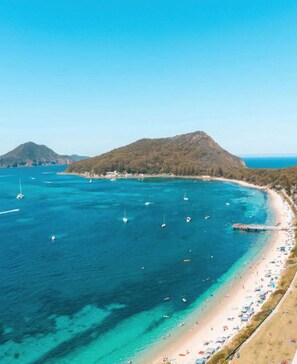 A coastal beach with clear turquoise waters, a sandy shore, and a mountainous backdrop. - Shore Thing - Shoal Bay (Shoal Bay)