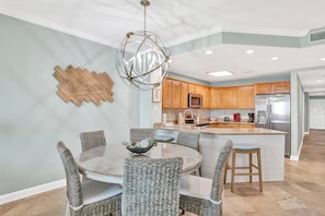 A modern kitchen with wooden cabinets, stainless steel appliances, and a central island.