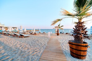 A beach with sun loungers and a wooden walkway leading to the water. - Marty's Beachfront Smart Homes (Sunny Beach)