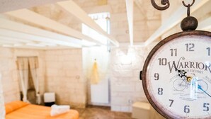 Ein Zimmer mit einem Bett, einer Wanduhr und einem Fenster.