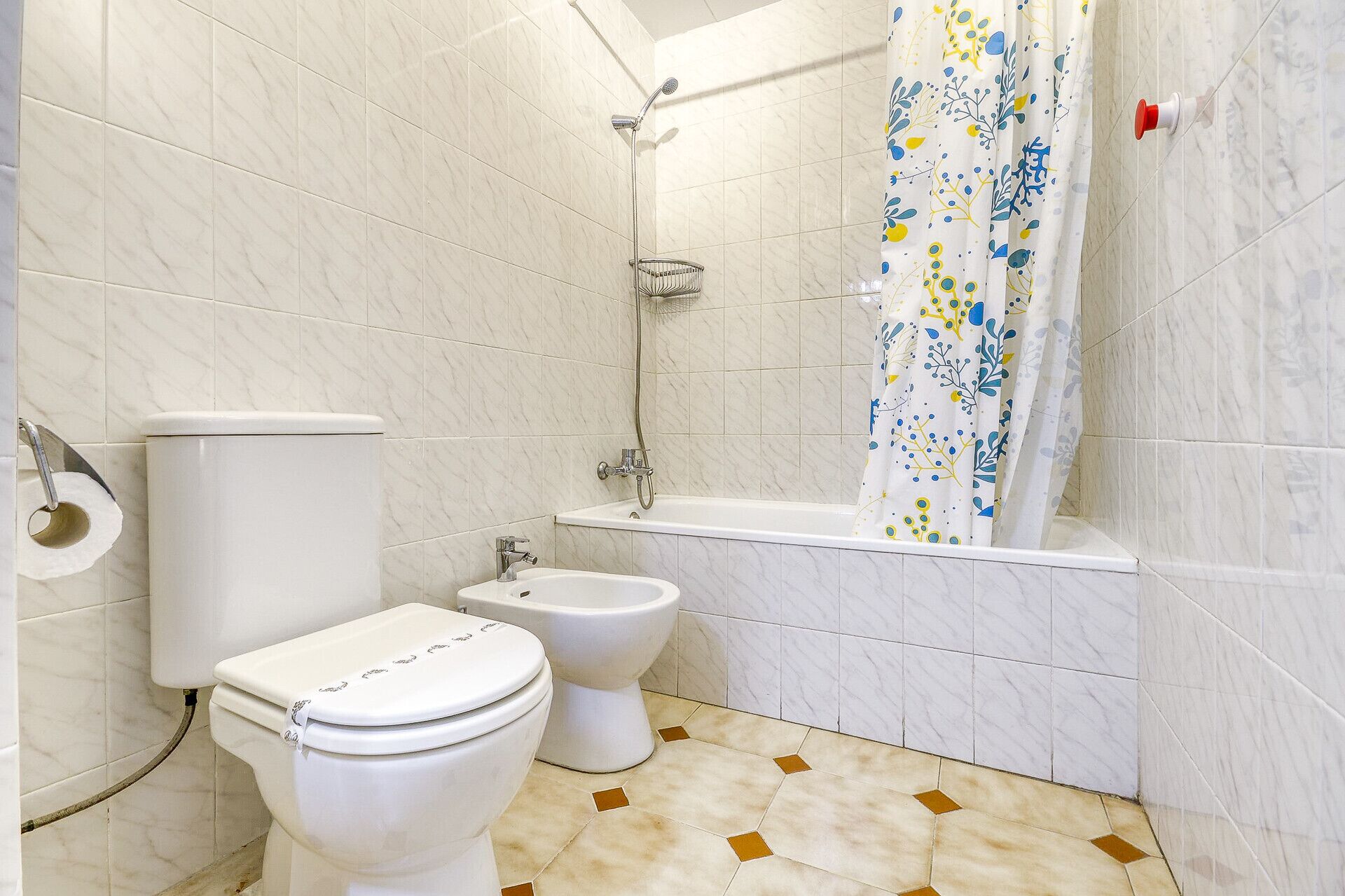 A bathroom with a toilet, bidet, and bathtub.