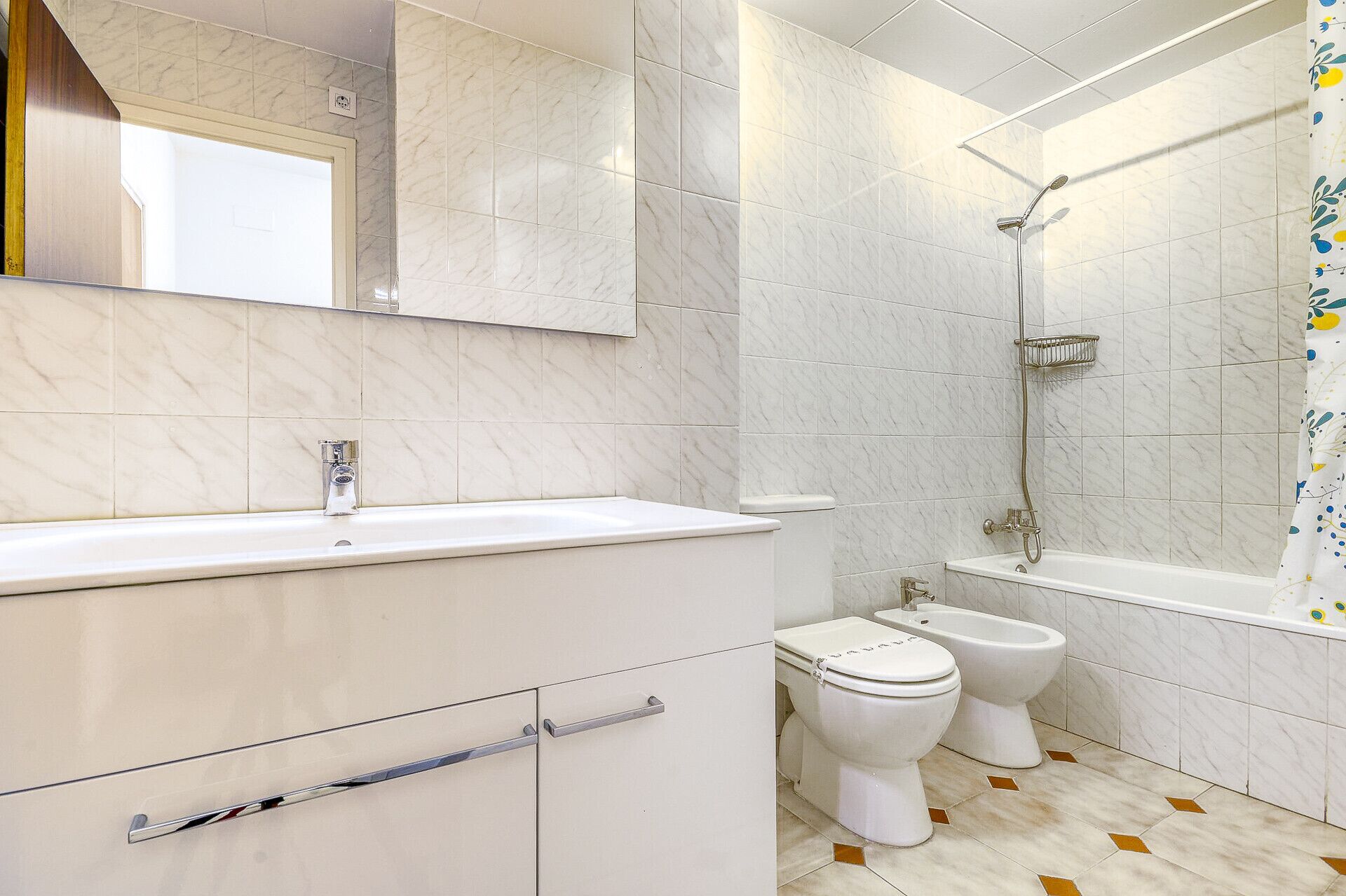Une salle de bain avec un lavabo blanc, des toilettes, un bidet et une baignoire.