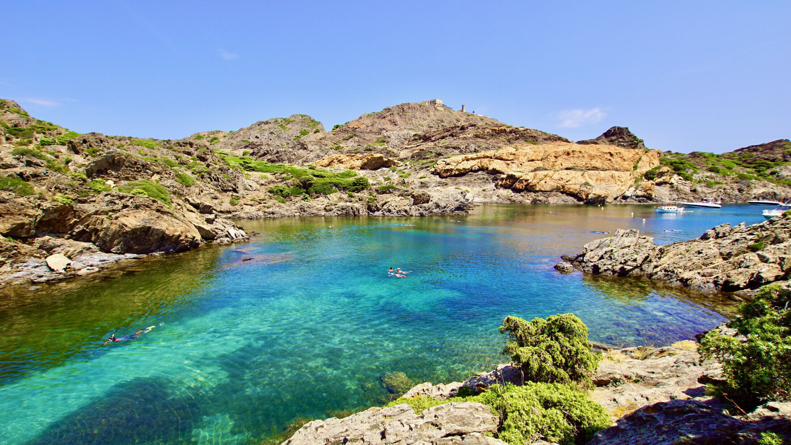 A clear coastal area with rocky terrain and a small body of water.