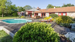 A house with a swimming pool, outdoor seating, and a garden. - Spacious family lodge with natural pool, near Nantes (La Limouzinière)