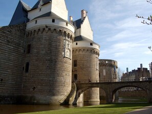 Um castelo histórico com múltiplas torres e uma ponte.