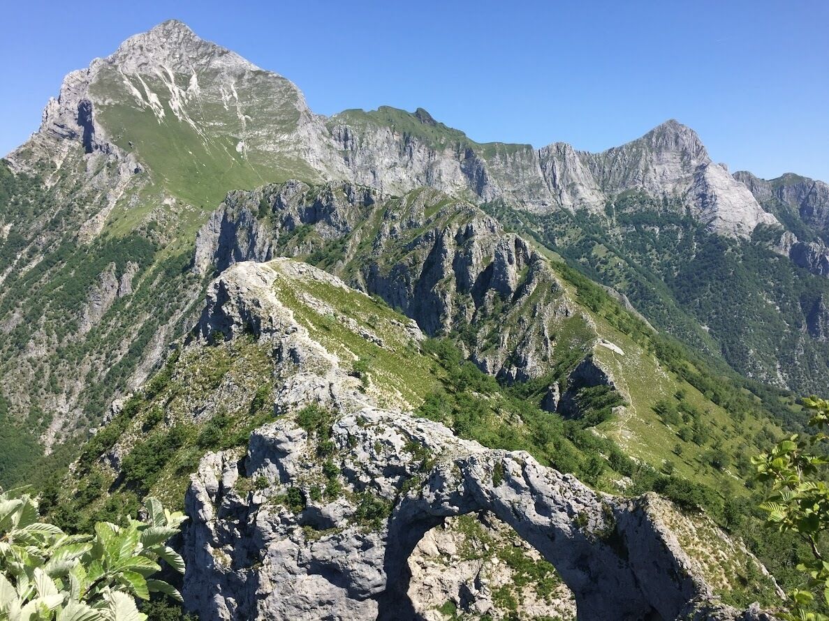 Un paysage montagneux avec une formation rocheuse imposante au premier plan.